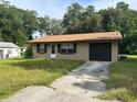 1-story house with brown roof and attached garage at 1215 E Hazzard Ave, Eustis, FL 32726