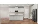 Modern kitchen with white shaker cabinets, large island, and stainless steel appliances at 10840 Bronson Rd, Clermont, FL 34711