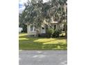 Small bungalow style home with stone foundation and lush landscaping at 5708 Se 109Th St, Belleview, FL 34420