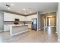 Modern kitchen with white cabinets, stainless steel appliances, and an island at 437 Silver Palm Dr, Haines City, FL 33844