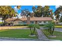 Single-story home with stone accents and a spacious lawn at 1241 W Lakeshore Dr, Clermont, FL 34711