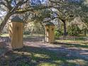 Elegant entrance gate with stone pillars and metal at 13524 Corkwood Ln, Astatula, FL 34705