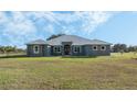 Single-story home with metal roof, stone accents, and a large yard at 2407 Cr 546N, Bushnell, FL 33513
