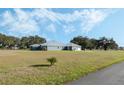 Single-story home with metal roof, stone accents, and a large yard at 2407 Cr 546N, Bushnell, FL 33513