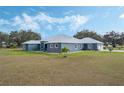 Single-story home with metal roof, stone accents, and a large yard at 2407 Cr 546N, Bushnell, FL 33513