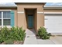 Welcoming teal front door and walkway leading to the home at 2720 Dumont Ln, Tavares, FL 32778
