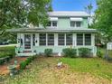 Quaint two-story house with light green siding and screened porch at 5905 Se Earp Rd, Belleview, FL 34420