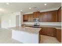 Modern kitchen with island, dark wood cabinets, granite countertops, and stainless appliances at 2000 Sunshine Peak Dr, Minneola, FL 34715