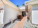 Side entry walkway with landscaping and decorative wind chimes at 32676 Oak Park Dr, Leesburg, FL 34748