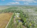 Aerial view of property showcasing home, pond, and surrounding woodland at 7024 Oil Well Rd, Clermont, FL 34714