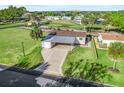 Property view showing home's location and carport in a lush green community at 1604 Magnolia Ave, The Villages, FL 32159
