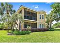Two-story house with screened balcony, lush landscaping, and a manicured lawn at 26142 Avenida Las Colinas # 2B, Howey In The Hills, FL 34737