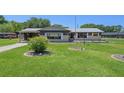Ranch-style home with carport and manicured lawn at 9930 County Road 114B, Wildwood, FL 34785
