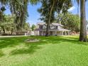 Large home with a spacious lawn, mature trees and a firepit at 10368 County Road 115A, Oxford, FL 34484