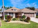 Single story house with two car garage, mature landscaping and driveway at 21125 Braveheart Dr, Leesburg, FL 34748