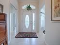 Bright and airy entryway with tile floors and a decorative rug at 1751 Ashwood Run, The Villages, FL 32162