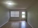 Bright and airy living room with tile floors and a door leading to a patio at 1100 E Caroline St # 115, Tavares, FL 32778