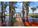 Wooden dock with gazebo extending over the lake, surrounded by cypress trees at 1261 W Lakeshore Dr, Clermont, FL 34711