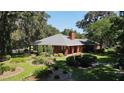 Brick home with landscaped gardens and a large backyard at 3554 County Road 216, Oxford, FL 34484