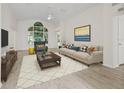 Bright living room featuring hardwood floors, comfy seating, and large windows at 102 Costa Mesa Dr, The Villages, FL 32159