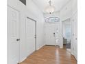 Bright and airy entryway with hardwood floors, a stained-glass window, and white doors at 1405 W Schwartz Blvd, The Villages, FL 32159
