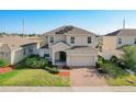 Two-story house with solar panels, two-car garage, and well-maintained lawn at 172 Seville Dr, Davenport, FL 33837