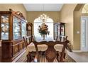 Formal dining room with a large table, china cabinets, and chandelier at 13144 Coldwater Loop, Clermont, FL 34711
