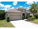 Tan one-story house with two-car garage at 316 Blue Cypress Dr, Groveland, FL 34736
