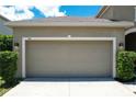 Two-car garage with tan exterior finish at 316 Blue Cypress Dr, Groveland, FL 34736