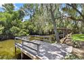 Wooden dock extending over calm water with lush greenery at 12270 Virginia Dr, Leesburg, FL 34788