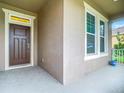 Inviting front door entrance with sidelights and a small covered porch at 4460 Linwood Trace Ln, Clermont, FL 34711