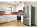 Bright kitchen with stainless steel appliances and wood flooring at 1113 Oakland Cir, Tavares, FL 32778