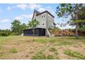 A green house with a screened porch overlooking a grassy landscape at 13910 Max Hooks Rd, Clermont, FL 34711