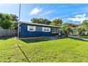 Charming ranch home with blue exterior and well-maintained lawn at 6919 Fern Cir, Leesburg, FL 34748