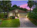 Single-story house with yellow exterior at sunset at 5068 Neptune Cir, Oxford, FL 34484