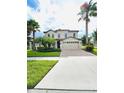 Two-story home with palm trees and driveway at 1300 Moss Creek Ln, Davenport, FL 33896