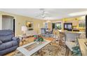 Open-concept living area with hardwood floors, stylish furniture, and kitchen views at 8084 Se 175Th Malmaison St, The Villages, FL 32162