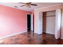 Bedroom with pink walls, tile floors, and a double-door closet at 14700 Se 94Th Ave, Summerfield, FL 34491