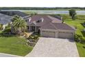 Luxury home with three-car garage,paved driveway and lake view at 3724 Conservation Trl, The Villages, FL 32163