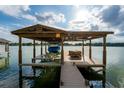 Covered boat dock with lift and seating area at 2537 E Crooked Lake Dr, Eustis, FL 32726