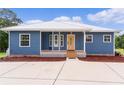 Blue house with metal roof and front porch at 4114 Dove Valley Ln, Lady Lake, FL 32159