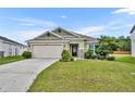 One-story house with a two-car garage, stone accents, and a landscaped lawn at 16696 Centipede St, Clermont, FL 34714