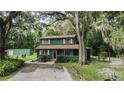 Green house with screened porch, surrounded by trees at 1773 C 44A, Wildwood, FL 34785