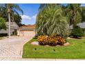 One-story house with paver driveway, landscaping, and palm trees at 7151 Se 173Rd Arlington Loop, The Villages, FL 32162