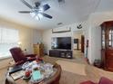 Living area with a TV, comfy seating, and a large window at 10645 Se 145Th St, Summerfield, FL 34491