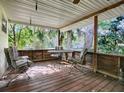 Wooden porch with metal furniture and view of trees at 853 Cr 484, Lake Panasoffkee, FL 33538
