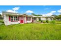 One-story house with red door and carport at 1620 Morin St, Eustis, FL 32726