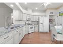 Bright kitchen with white cabinets, granite counters, and stainless steel appliances at 6002 Sailboat Ave, Tavares, FL 32778