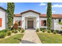 Front entrance of Mediterranean style home with landscaping at 7616 Lily Ct, Groveland, FL 34736