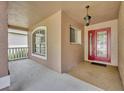 Covered front porch with red door entry at 3921 Doune Way, Clermont, FL 34711